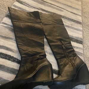 Black leather over the knee boots, wedged heel.